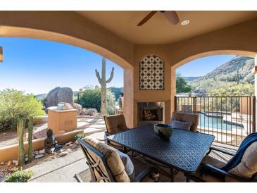 Covered patio with fireplace, seating area, and mountain views at 14597 E Corrine Dr, Scottsdale, AZ 85259