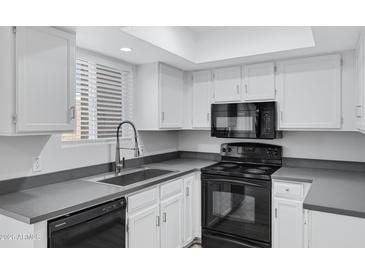 Well-equipped kitchen with white cabinets and black appliances at 17242 N 16Th Dr # 9, Phoenix, AZ 85023