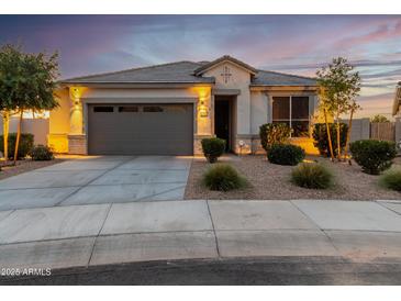 One-story home with gray garage door, landscaping, and a welcoming front porch at 18280 N Piccolo Dr, Maricopa, AZ 85138