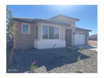 Single-story home with modern facade, attached garage, and landscaped front yard at 19009 W Maryland Ave, Waddell, AZ 85355