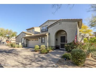 Two-story home with Spanish-style architecture, two-car garage, and landscaped front yard at 20802 N Grayhawk Dr # 1173, Scottsdale, AZ 85255