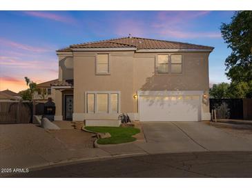 Two-story house with a tan exterior, white garage door, and landscaped front yard at 3141 S 83Rd Cir, Mesa, AZ 85212