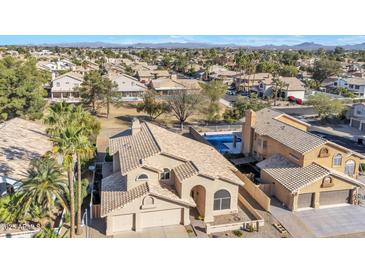 Expansive aerial view of a Southwestern home with a tile roof, palm trees, and community pools at 4968 E Grandview Rd, Scottsdale, AZ 85254