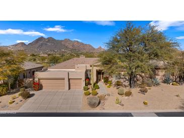 Single-story home with a two-car garage and desert landscaping at 6358 E Evening Glow Dr, Scottsdale, AZ 85266