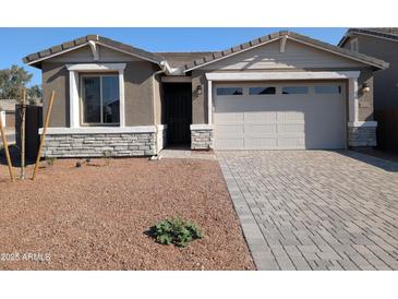 One-story home with light brown exterior, two-car garage, and paver driveway at 8333 N 54Th Ln, Glendale, AZ 85302