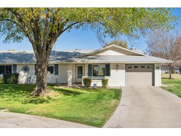 Single-story home with a landscaped lawn and attached garage at 9518 W Shasta Dr, Sun City, AZ 85351