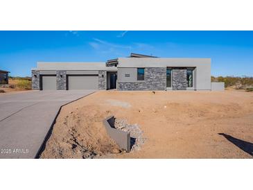 Modern home with stone accents and three-car garage at 25580 N 119Th St, Scottsdale, AZ 85255