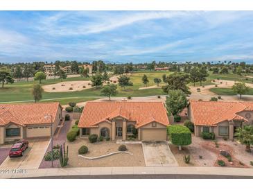 Inviting single-story home with terra cotta roof and desert landscaping, backing onto a golf course at 9447 W Tonto Ln, Peoria, AZ 85382