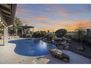 Inviting pool with waterfall feature and sunset views at 14801 N 22Nd Ln, Phoenix, AZ 85023