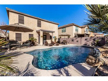 Inviting backyard pool with patio furniture and landscaping at 45707 W Barbara Ln, Maricopa, AZ 85139
