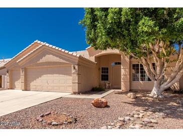 Charming single-story home featuring a desert-landscaped front yard and a spacious two-car garage at 11606 W Laurelwood W Ln, Avondale, AZ 85392