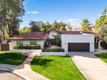 Single-story home with red tile roof, landscaped yard, and two-car garage at 12286 N 86Th Pl, Scottsdale, AZ 85260