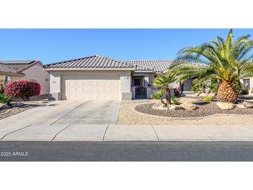 Single-story home with desert landscaping, driveway, and two-car garage at 19608 N Papago Dr, Surprise, AZ 85374