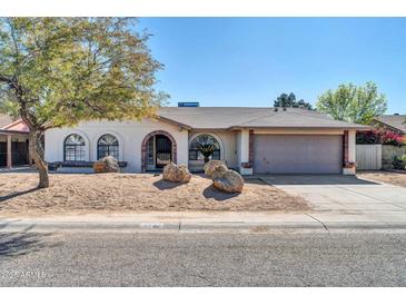 Single-story home with a two-car garage and landscaping at 7357 W Canterbury Dr, Peoria, AZ 85345