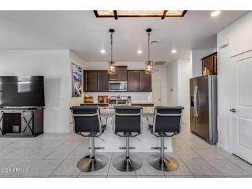 Modern kitchen with granite counters, stainless steel appliances, and an island with seating at 14168 W Georgia Dr, Surprise, AZ 85379