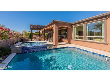 Inviting backyard pool and spa with covered patio, perfect for entertaining and relaxation at 267 E Santa Lucia Ln, Queen Creek, AZ 85140