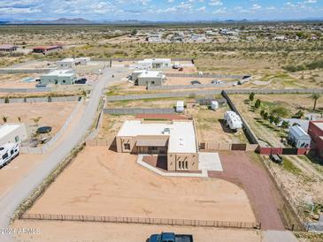 Aerial view of a single-story house with a large yard and surrounding desert landscape at 30039 N 209Th Ave, Wittmann, AZ 85361