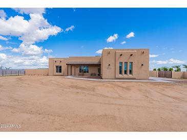 Front view of a single-story house with stucco exterior and a desert landscape at 30039 N 209Th Ave, Wittmann, AZ 85361