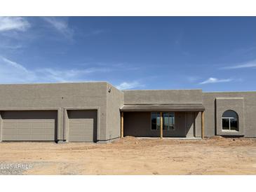 Modern home featuring a stucco exterior, covered porch, arched window, and convenient two-car garage at 30039 N 209Th Ave, Wittmann, AZ 85361