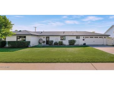 Charming single story home with a well manicured lawn and two car garage at 4901 E Flower St, Phoenix, AZ 85018