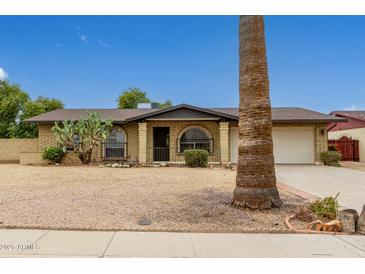 Ranch style home with brick facade, attached garage, and desert landscaping at 5530 N 47Th Ave, Glendale, AZ 85301