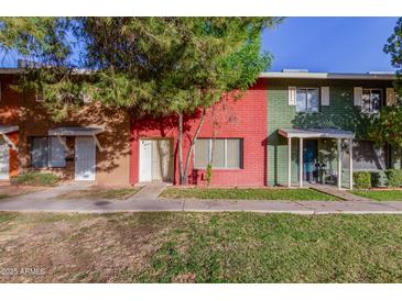 Two-story building with red and green painted brick exterior and grassy lawn at 6654 N 43Rd Ave, Glendale, AZ 85301