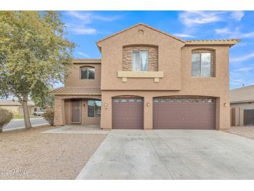 Two-story house with brown exterior, two-car garage, and desert landscaping at 1036 E Oak Rd, San Tan Valley, AZ 85140