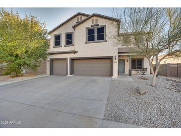 Two-story house with a three-car garage and desert landscaping at 30313 W Mitchell Ave, Buckeye, AZ 85396