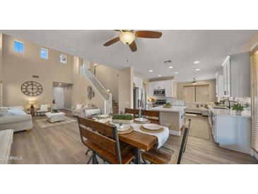 Bright dining area features a rustic wood table set, flowing into the living room and kitchen for open-concept living at 3462 E Riopelle Ave, Gilbert, AZ 85298