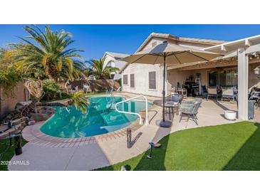 Stunning pool area, complete with patio furniture and lush landscaping at 14995 W Desert Hills Dr, Surprise, AZ 85379