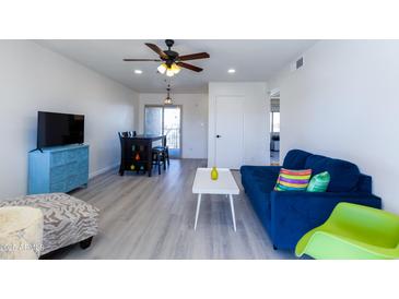 Bright living room with wood-look floors, comfy sofa, and dining area at 2220 W Dora St # 215, Mesa, AZ 85201