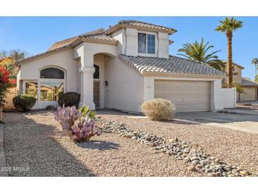 Two-story house with desert landscaping, a two-car garage, and a light-colored exterior at 3212 N 109Th Ave, Avondale, AZ 85392