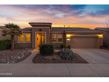 Beautiful desert landscaping surrounds this single-story home with a 3-car garage at 42585 W Heavenly Pl, Maricopa, AZ 85138