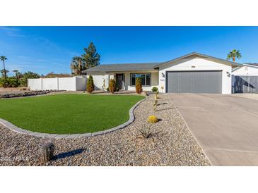 Landscaped front yard with artificial turf and drought-tolerant plants at 5266 E Blanche Dr, Scottsdale, AZ 85254