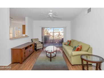 Bright living room with wood floors, patio access, and comfy seating at 14950 W Mountain View Blvd # 6301, Surprise, AZ 85374