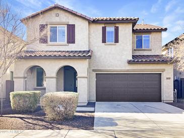 Two-story house with brown garage door and Spanish-style roof at 26520 N 132Nd Ln, Peoria, AZ 85383
