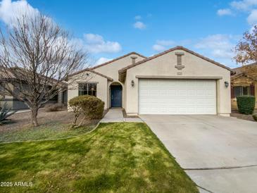 Single-story home with a two-car garage and well-manicured lawn at 41876 W Corvalis Ln, Maricopa, AZ 85138