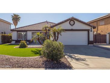 House exterior features a single-story design, white walls, and a brown tile roof at 10873 W Carlota Ln, Peoria, AZ 85373