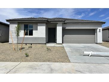Charming single-story home featuring neutral stucco, gray trim, and a well-manicured gravel yard at 24098 W Sunland Ave, Buckeye, AZ 85326