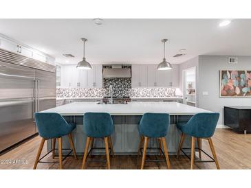 Modern kitchen features stainless steel appliances and a large island with seating at 4639 E Mountain View Ct, Phoenix, AZ 85028
