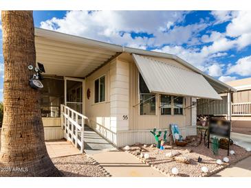 Inviting single-wide manufactured home with covered porch and landscaped yard at 9333 E University Dr # 55, Mesa, AZ 85207