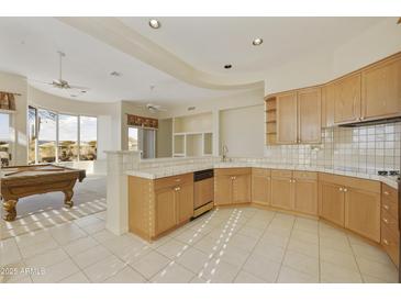 Spacious kitchen with ample cabinetry and views of the game room at 9514 E Cavalry Dr, Scottsdale, AZ 85262