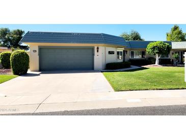Attached garage with a green door and a spacious driveway at 10529 W Pineaire Dr, Sun City, AZ 85351