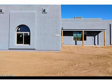 Modern exterior of a newly built house with custom arched window and tan exterior walls at 24235 N 194Th Ave, Surprise, AZ 85387