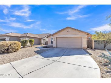 Tan house with a two-car garage and landscaped front yard at 44611 W Mescal St, Maricopa, AZ 85138