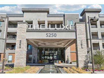 The Luxe 5250 building entrance, featuring a modern design with stone accents and water feature at 5250 E Deer Valley Dr # 450, Phoenix, AZ 85054
