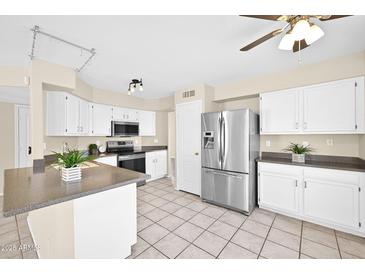 Bright kitchen featuring white cabinets, stainless steel appliances, and tiled flooring at 659 S Dodge St, Gilbert, AZ 85233