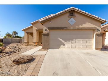 Single-story home with attached garage and desert landscaping at 1102 N 5Th St, Buckeye, AZ 85326