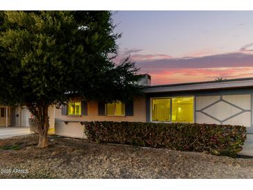 Ranch style home with attached garage and manicured landscaping at 11024 W Peoria Ave, Sun City, AZ 85351