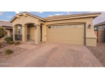 Tan house with a two-car garage and a paved driveway at 34357 N Red Clay Rd, San Tan Valley, AZ 85144